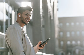 šťastný muž, chytrý telefon, ulice, špunty, usmívající se, venku, hudba, moderní životní styl, mladý muž, sdělení, technologie