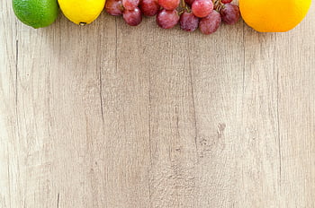 assorted-color fruits, brown surface, fresh oranges, grapes, lemon, lime, wooden chopping board, vibrant colors, fruit arrangement, healthy food, natural ingredients