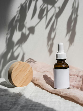 produk perawatan kulit, bidikan close-up, Serum perawatan kulit, botol krim, Kecantikan organik, latar belakang kain, Presentasi Bergaya, perawatan kulit alami, tema kecantikan, desain minimalis, efek bayangan