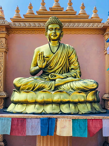 Golden Buddha Statue, serene temple setting, spirituality, peace, red and blue textile, magnificent statue, temple architecture, spiritual art, peaceful ambiance, cultural heritage, golden sculpture