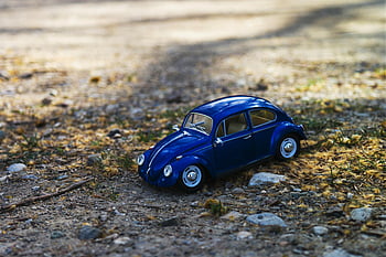 samochód żuk niebieski, Miniaturowy samochód zabawkowy, Chrząszcz volkswagen, Słoneczna ścieżka żwiru, otoczenie natury, scena plenerowa, niebieski samochód, pojazd zabawkowy, ścieżka kamienna, naturalne otoczenie, miniaturowy model