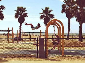 femeie care joacă swing, plajă, plaja din Veneția, los angeles, california, Copiii se bucură de leagăn, palmieri, loc de joaca, activitati in aer liber, distracție de vară, timp pentru familie