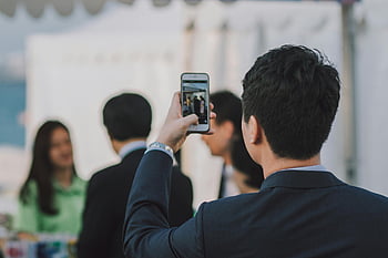 man taking picture, people, man in suit, photographing colleagues, smartphone, business event, outdoors, group photo, professional event, event photography, outdoor gathering
