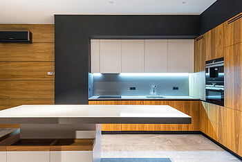 cuisine élégante, zone de cuisson illuminée, Appareils modernes, accents en bois, cuisine contemporaine, design élégant, Éclairage sous le cabinet, style minimaliste, îlot de cuisine, lignes épurées, armoires modernes