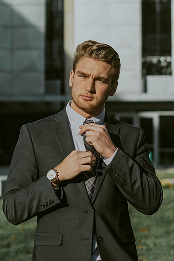 elegant young businessman, bearded businessman, suit and tie, downtown, modern building, adjusting tie, outdoors, confident, professional, business attire, urban setting