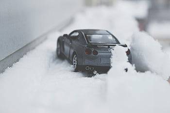 toy car, snow, winter scene, black toy car, partially buried, close-up photo, automotive scene, winter automotive, toy car in snow, snow-covered toy car, winter toy car