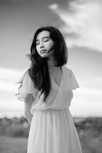 mindful Asian woman, elegant dress, countryside, serene, calm, white dress, outdoor portrait, eyes closed, young woman, black and white, peaceful setting