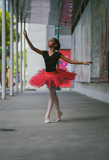ballerina, red tutu, ballet dancer, outdoor performance, vibrant tutu, elegance, poise, ballet shoes, urban setting, artistic dance, grace