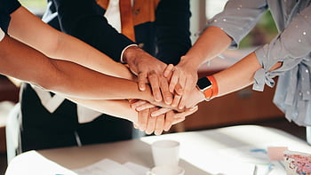 teamwork, stacking hands, unity, collaboration, diverse team, close-up shot, white table, group activity, team spirit, hands together, business team
