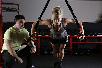 woman doing exercise, strength training, gym setting, fitness, dedication, personal trainer, workout, exercise equipment, fitness routine, gym workout, fitness goals