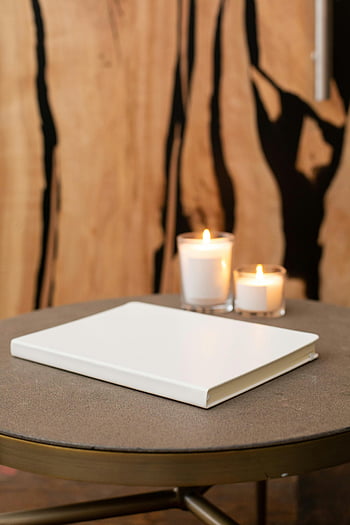 zesměšňovat knihu, bílý notebook, svíčky, Stylový stůl, dřevěný dekor, minimalistický design, nastavení tabulky, domovní dekorace, Vzhled interiéru, Útulná atmosféra, Ambiance při svíčkách