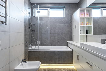modern dizájnú fürdőszoba, modern fürdőszoba, elegáns szürke csempék, fürdőkád, zuhany, hiúság, fehér hiúság, üveg zuhany, Fürdőszoba kialakítása, szürke fürdőszobai csempék