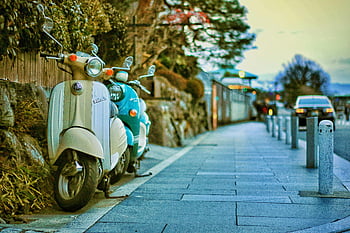 beige motor scooters, teal motor scooters, Kyoto street, vintage ambiance, travel vibe, classic motor scooters, dusk scene, charming street, parked scooters, vintage travel, Kyoto ambiance