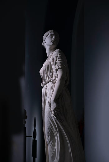 Greek Goddess Statue, Neo-Classical statue, elegant drapery, shadowy interior, Greek goddess, classical art, marble sculpture, ancient Greece, art museum, cultural heritage, historical figure