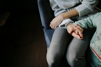 mother and child, holding hands, seated together, warmth and connection, gray long-sleeved shirt, blue long-sleeved shirt, close-up photo, family bond, intimate moment, motherhood, child care