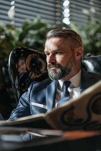 man reading newspaper, professional businessman, beard, formal setting, indoor, suit, tie, newspaper, office, business attire, reading