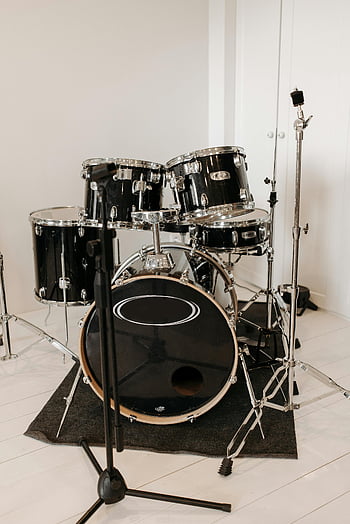 black drum set, silver drum set, microphone stand, minimalistic studio, indoor music studio, black drums, silver hardware, music equipment, drum kit, studio setup, drum set photography