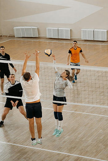 volleyball, indoor volleyball, woman spiking, dynamic action, athletes competing, indoor sports, volleyball match, sports action, volleyball court, competitive sports, volleyball players