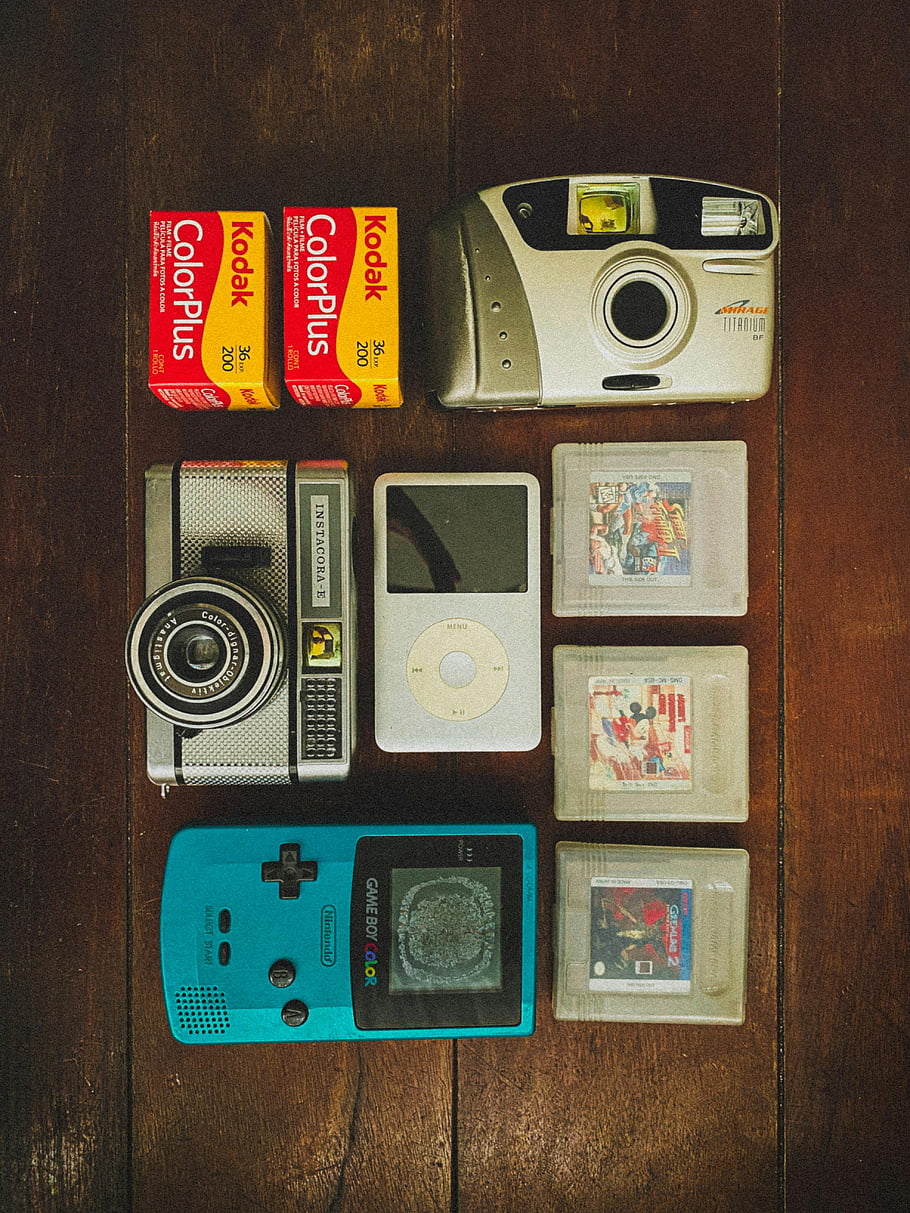 Vintage elektronika, dřevěné pozadí, ploché ležel, kamer, ipod, hráč, Retro gadgety, kodak film, Instacora Camera, hra chlapec barvy, Vintage technologie
