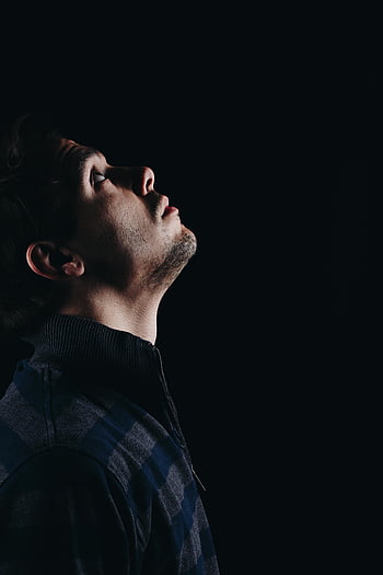 black and blue polo shirt, side profile portrait, dramatic shadows, man looking upward, artistic photography, dark background, male fashion, stylish outfit, high contrast, fashion photography, portrait photography