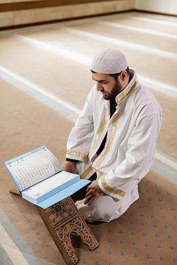 Muslim man, traditional attire, reading Quran, mosque, religious devotion, culture, kneeling, book, prayer, Islamic, faith