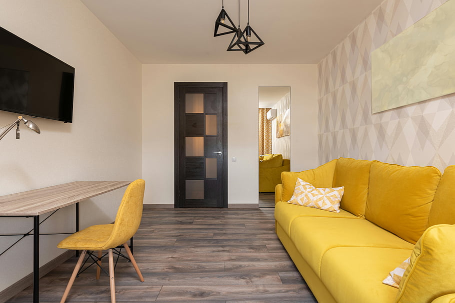 moderní byt, žlutá pohovka, dřevěné podlahy, Geometrický výzdoba, útulný obývací pokoj, žlutá barva, Vzhled interiéru, Současný styl, pohodlný život, moderní dekor, žlutý nábytek