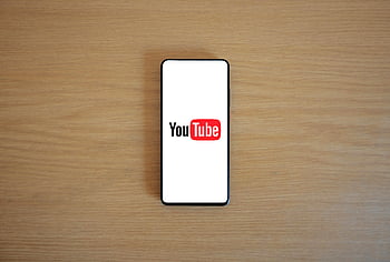 YouTube logo, smartphone, top view, wooden surface, modern technology, YouTube app, mobile device, digital display, tech gadget, screen shot, YouTube interface