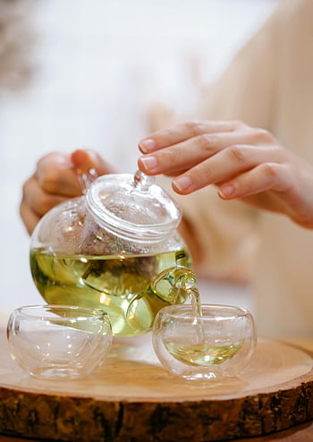 Tee gießen, grüner Tee, Teekanne, Glasbecher, Nahansicht, Gelassener Moment, Tee-Zeremonie, Teezeit, Teekultur, Tee trinken, Teezubereitung