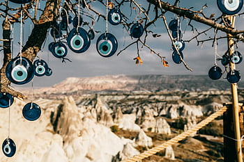 glass amulets, Nazar charms, tree, Göreme National Park, Turkey, unique rock formations, hanging ornaments, blue glass, evil eye, natural landscape, cultural symbols