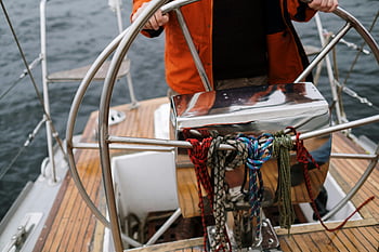 timone della barca a vela, Mano di marinaio, Navigazione del mare, marinaio ravvicinato, sterzo della barca a vela, Navigazione del mare aperto, Avventura a vela, Controllo della barca, Navigazione marittima, attrezzatura da vela, marinaio