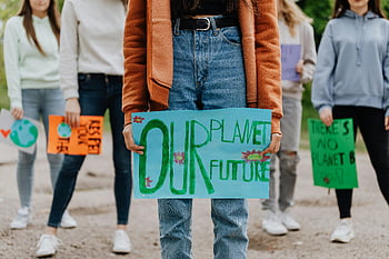 climate change protest, young activists, handmade signs, outdoor protest, placards, environmental activism, climate action, eco-friendly, sustainable future, planet Earth, protest signs