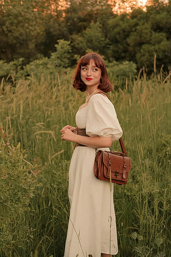 retro portrét, žena v šatech, vintage šaty, retro vibe, Slunce zalité louky, Žena s peněženkami, venkovní portrét, přirozené světlo, prastarý styl, luční scéna, Klasická móda