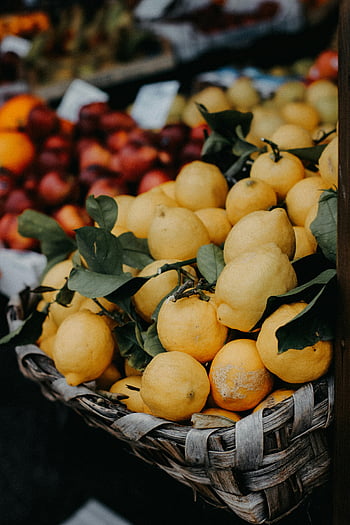 limoni, cestino, bancarella, mercato all'aperto, limoni freschi, cestino rustico, temi culinari, scatto vibrante, esposizione di frutta, prodotti del mercato, limoni gialli