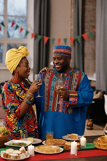 Oslava Kwanzaa, tradiční oblečení, Slavnostní jídlo, šťastný pár, Víno společně, africký oděv, Domácí oslava, kulturní akce, Shromažďování prázdnin, Tradiční pokrývka hlavy, slavnostní dekorace