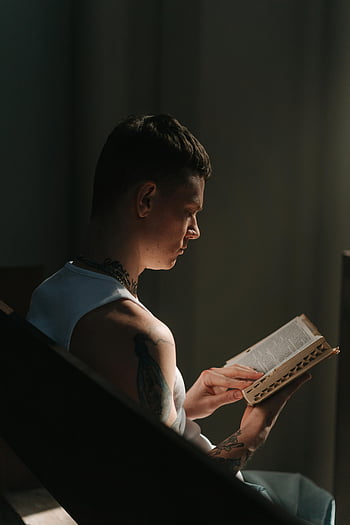 Muž, který čte Bible, mladý muž, Dimaly osvětlená místnost, rozjímání, introspekce, tetování, rezervovat, náboženské čtení, duchovní, krytý, zaměřené