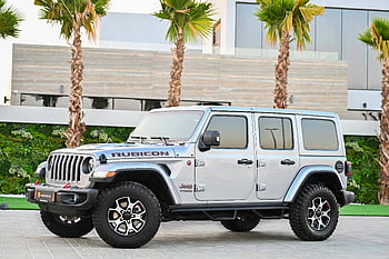 Silver Jeep Wrangler, Rubicon SUV, modern Dubai, parked, silver vehicle, off-road vehicle, luxury car, urban setting, palm trees, modern architecture, Jeep brand