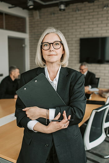 Senior forretningskvinde, sort blazer, Sort udklipsholder, formel påklædning, Kontorindstilling, møde, professionel kvinde, forretningsmøde, virksomhedsmiljø, Ældre professionel, arbejdsplads
