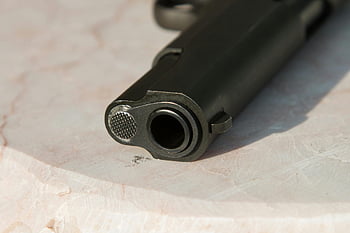 gun barrel, black metal gun, white surface, marble surface, detailed close-up, metal texture, firearm details, gun parts, close-up photography, gun photography, gun barrel texture