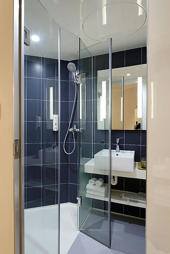 moderní koupelna, Skleněná sprcha, moderní design, Elegantní koupelna, čiré sklo, koupelna, Design koupelny, moderní sprcha, Koupelnové prvky, modré dlaždice, bílé umyvadlo