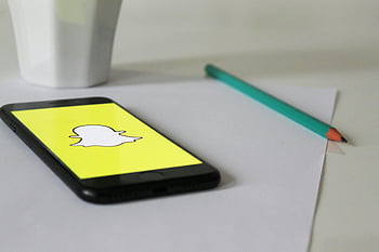 černý iphone 7, logo snapchat, bílý papír, lavice, tužka, džbánek, sociální média, technologie, chytrý telefon, Žlutá obrazovka, bílé pozadí