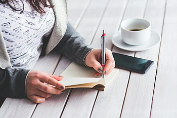 donna che scrive, penna, bloc notes, rivista, tazza di caffè, smartphone, tavolo di legno, Prendere appunti, Journaling quotidiano, produttività, spazio di lavoro