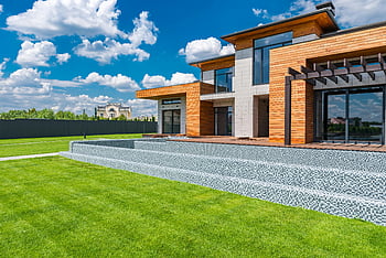 modern villa, glass walls, contemporary house, wooden exterior, large windows, spacious green lawn, sunny day, courtyard design, modern architecture, outdoor living space, villa exterior