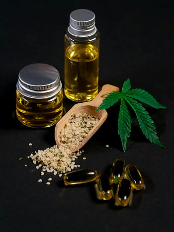 منتجات Cbd،  زيت القنب،  جرة بلاستيكية شفافة،  بذور القنب،  ورقة القنب،  خلفية مظلمة،  كبسولات CBD،  مغرفة خشبية،  المكملات الطبيعية،  منتجات العافية،  الطب البديل
