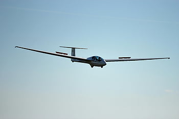 glider plane, clear blue sky, aviation precision, sleek design, flying gracefully, white aircraft, single-wing plane, aerodynamic shape, outdoor aviation, sky sports, precision flying