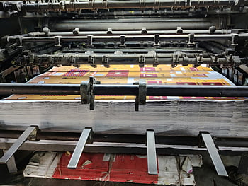 printing machine, close-up, industrial printing, paper sheets, factory setting, manufacturing process, printing technology, industrial equipment, production line, printing press, machinery