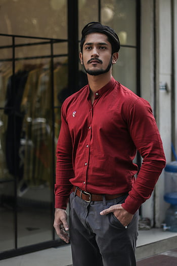 Mann, rotes Shirt, Graue Hosen, Klarglasfenster, Bekleidungsgeschäft, Stilvoller Mann, selbstbewusste Pose, Outdoor -Mode, urbaner Stil, männliche Mode, Streetstyle