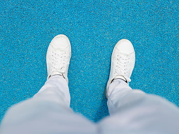 Białe tenisówki, spodnie dresowe, niebieska powierzchnia, widok z góry, obuwie na co dzień, buty sportowe, wygodne buty, sportowy wygląd, styl uliczny, moda, styl życia