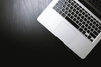 jablko macbook, Elegantní notebook, pohled shora, Tmavý dřevěný stůl, moderní technologie, černá klávesnice, stříbrný notebook, minimalistický design, Technologická fotografie, nastavení stolu, Estetika pracovního prostoru