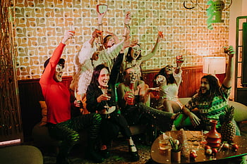 folk har det sjovt, parti, drikkevarer, latter, Hyggelige indendørs indstilling, livlig gruppe, venner fejrer, Festlig atmosfære, Social sammenkomst, fest, fest dekorationer