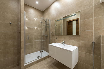 moderní koupelna, Skleněná sprcha, keramická dlažba, nástěnné zrcadlo, elegantní design, koupelna, poblíž toalety, velké dlaždice, bílé umyvadlo, minimalistický design